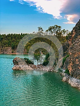 Wild Spanish nature landscape beautiful blue lake and mountains in clouds and pink sunset