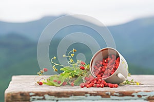 Wild strawberries on a wooden table.