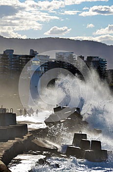 Wild waves splashing people near lighthouse