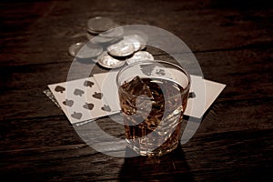 Wild west gambling. Dead man`s hand, silver coins and whiskey shot. Two-pair poker hand consisting of the black aces and black