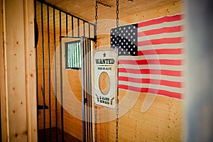 Wild West jail door and wanted sign with american flag in the ba