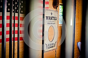 Wild West jail and wanted sign with american flag in the background