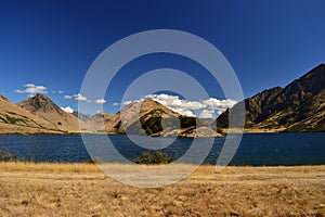 Wild west landscape, blue lake, dry mountains, savannas, desert land photo
