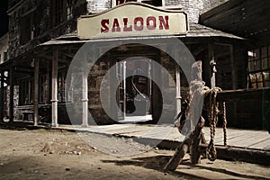 Wild west saloon front with hitch rack at night