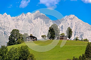 Wilder Kaiser, alpine massif, rugged mountains, green meadows, log cabins, Austria photo