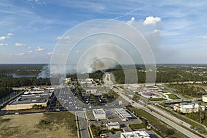 Wildfire burning severely during dry winter season in North Port city, Florida. Thick smoke rising up over suburb homes