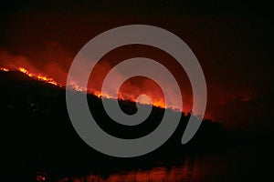 Wildfire disaster - fire burning mountain in night time
