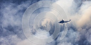 Wildfire Service Helicopter flying over BC Forest Fire and Smoke on the mountain near Hope