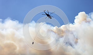 Wildfire Service Helicopter flying over BC Forest Fire and Smoke on the mountain near Hope