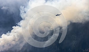 Wildfire Service Helicopter flying over BC Forest Fire and Smoke on the mountain near Hope