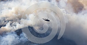 Wildfire Service Helicopter flying over BC Forest Fire and Smoke on the mountain near Hope