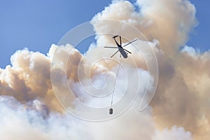 Wildfire Service Helicopter flying over BC Forest Fire and Smoke on the mountain near Hope