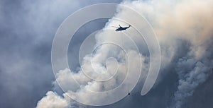 Wildfire Service Helicopter flying over BC Forest Fire and Smoke on the mountain near Hope