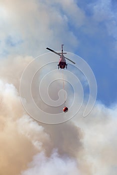 Wildfire Service Helicopter flying over BC Forest Fire and Smoke on the mountain near Hope