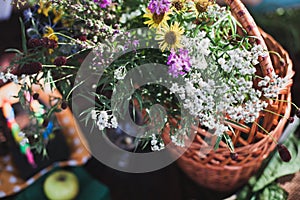 Wildflowers bouquet in glass vase on wooden background