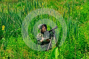 Wildlife explorer records the results of the observations while standing among the tall grass in the wetland