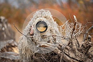 Wildlife photographer in the ghillie suit working