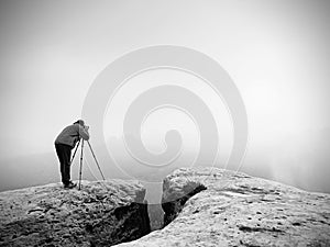 Wildlife photographer on mountain summit works. Man like to travel and photography, taking pictures