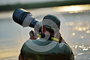 Wildlife photographer outdoor, standing in the water