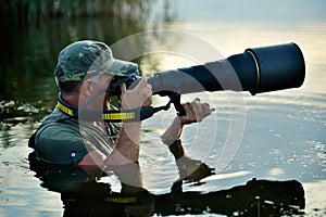 Wildlife photographer outdoor, standing in the water