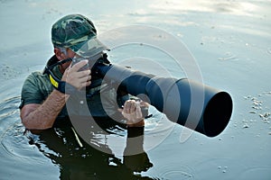 Wildlife photographer outdoor, standing in the water