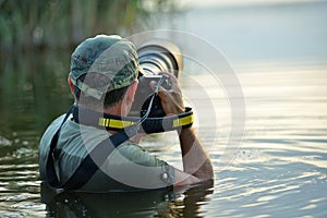 Wildlife photographer outdoor, standing in the water