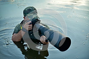 Wildlife photographer outdoor, standing in the water