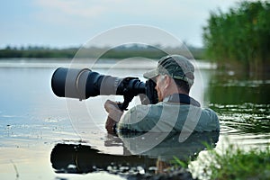 Wildlife photographer outdoor, standing in the water