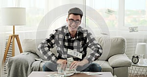 Wildly Excited Caucasian Man Scatters Money in Living Room