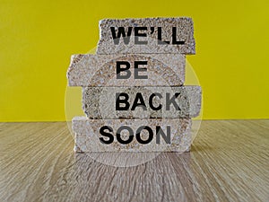 We will be back soon symbol. Concept words We will be back soon on brick blocks on a beautiful yellow background. Business, we