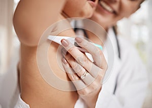 This will be a bit cold. Shot of a paediatrician taking a babys temperature with a thermometer.