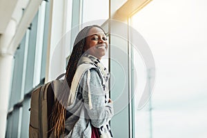 This will be my first time flying. Cropped shot of a young woman looking at out the airport window while waiting for