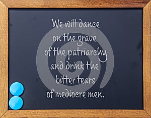 We will dance on the grave of the Patriarchy - Wood framed blackboard with two turqoise magnets in corner - textured background photo