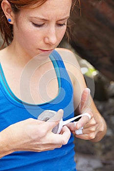 This will help immensely with her grip. Closeup of a rock climber taping her fingers. photo
