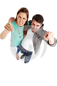 We will hold you accountable. High-angle shot of a young couple in a studio pointing their fingers at you angrily.