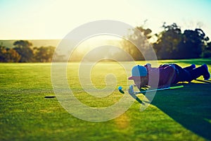 Will he make it or miss it. a young man eyeing up the putt during a round of golf.