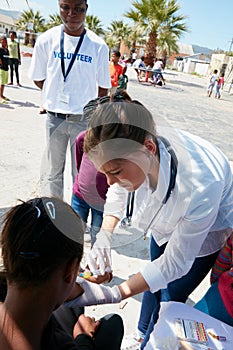 This will make you better in no time. a volunteer nurse giving injections to underprivileged kids. photo