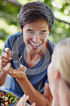 Will you be my missus. Shot of a handsome young man proposing to his girlfriend with an engagement ring.