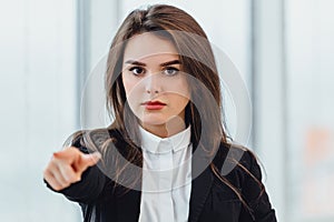 Will you join my team Young woman in suit pointing at camera, looking confident and determined.