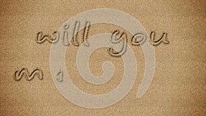 Will you marry me proposal written in sand.