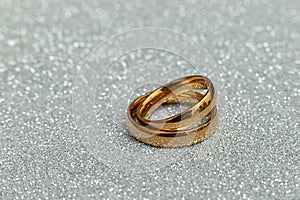 Will you marry me. Two golden wedding rings on silver glitter background. Engagement marriage proposal wedding
