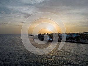 Willemstad city in Curacao surrounded by the ocean with a bright sunset in the background