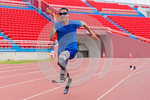 Willful Asian athlete speeds up on stadium track, aiming to break his record with prosthetic blades photo