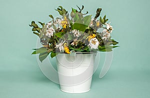 Wilted bouquet in white pail