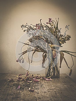 Wilted flowers bouquet in a glass vase ,Vintage filtered