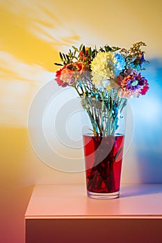 Wilted flowers in red water in colored light