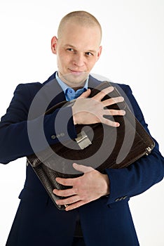 Wily caucasian man in suit holding briefcase in hands on white background.