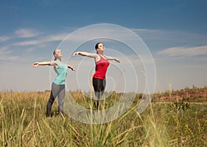 Wimen doing yoga outdoors nature shows poses photo