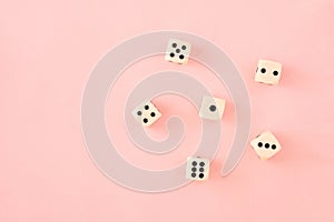 Wimple pattern or wallpaper with white and black gaming board game dice on bright pink background. Flat lay view photo