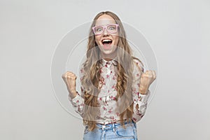 Win! Beautiful long haired blonde woman shout and have a happiness look